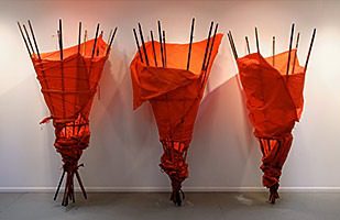 Three red fabric-wrapped sculptures